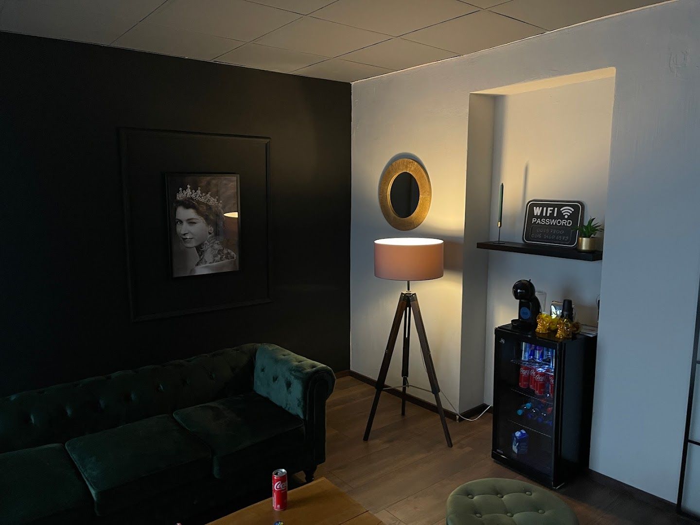 a living room with a green couch and a black wall