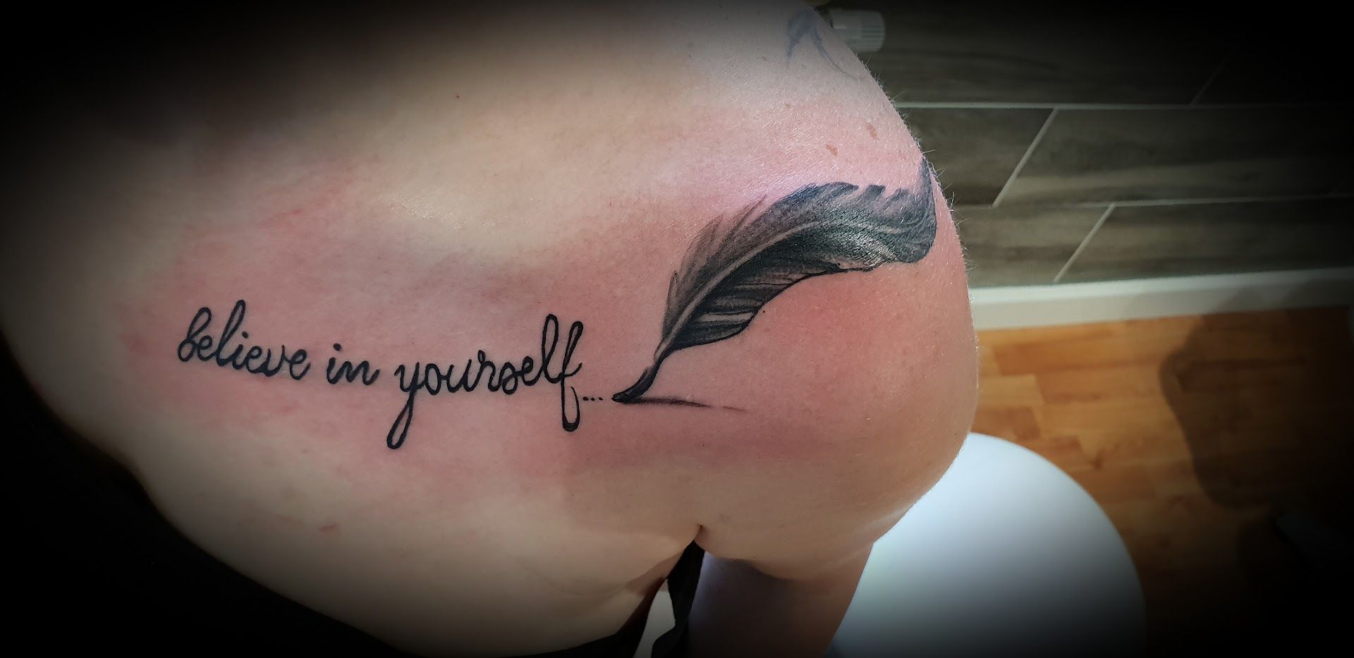 a woman's shoulder with a feather cover-up tattoo on it, uckermark, germany