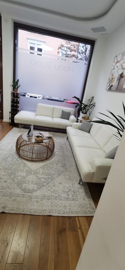 a living room with a large white couch and a large white rug