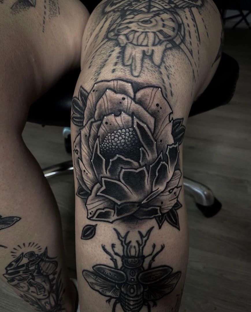 a black and white cover-up tattoo with a rose on the thigh, zwickau, germany