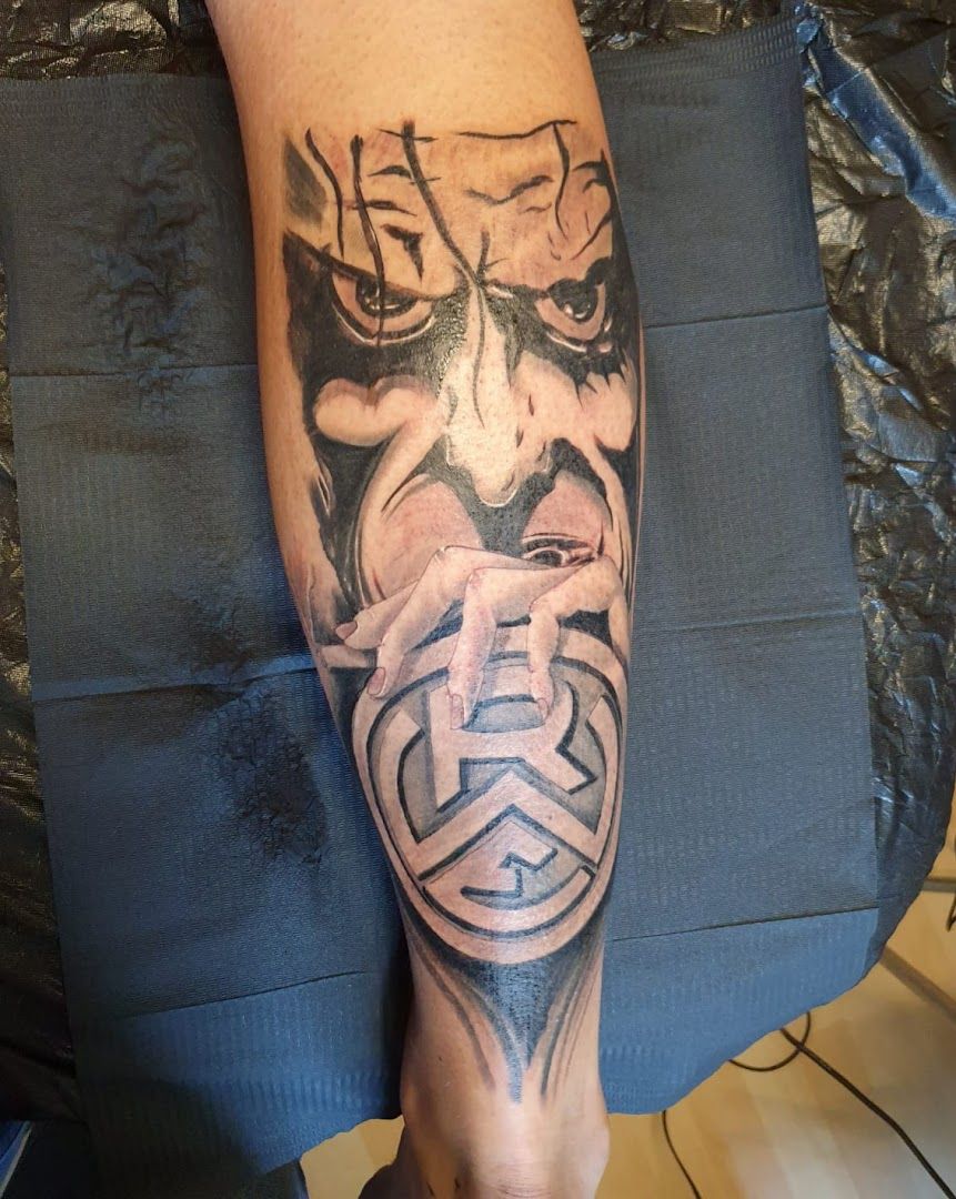 a cover-up tattoo of a man's face with a mask on his leg, essen, germany