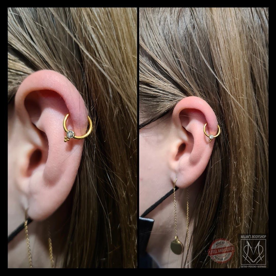 a woman wearing a gold ear piercing