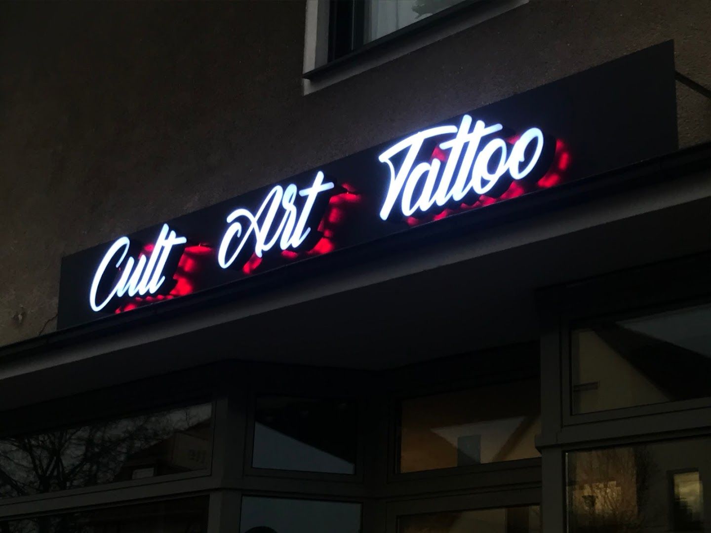 a neon sign that reads cut out narben tattoo, bielefeld, germany