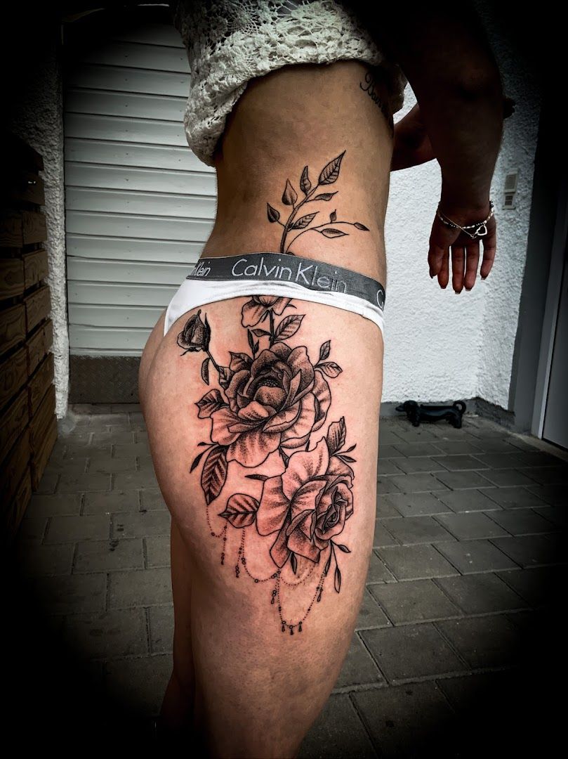 a woman's thigh with a rose narben tattoo on it, munich, germany