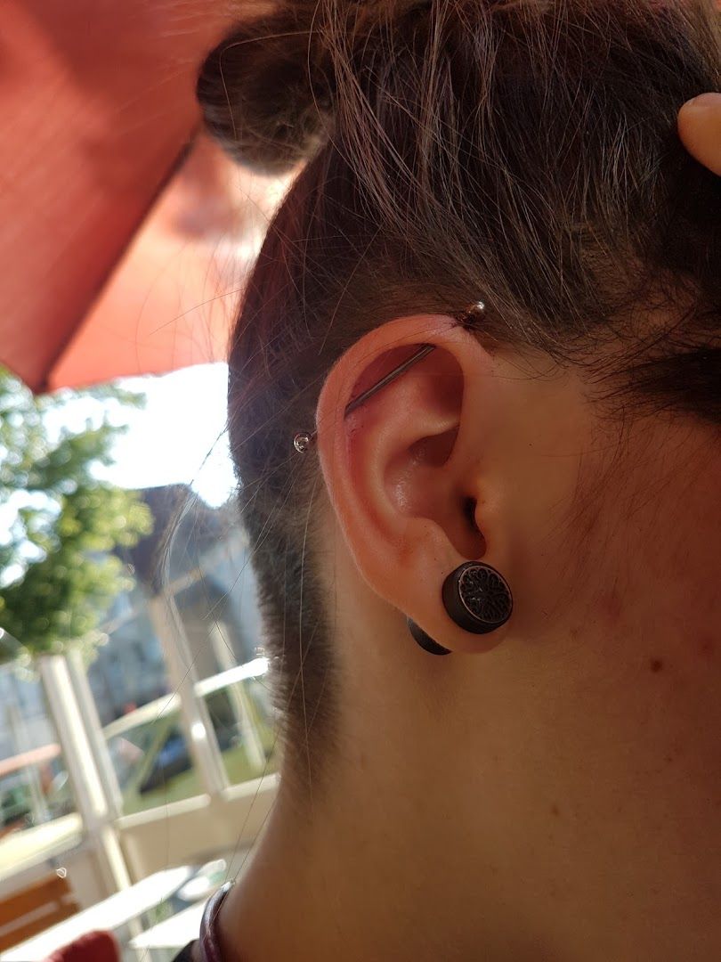 a woman with a black ear piercing