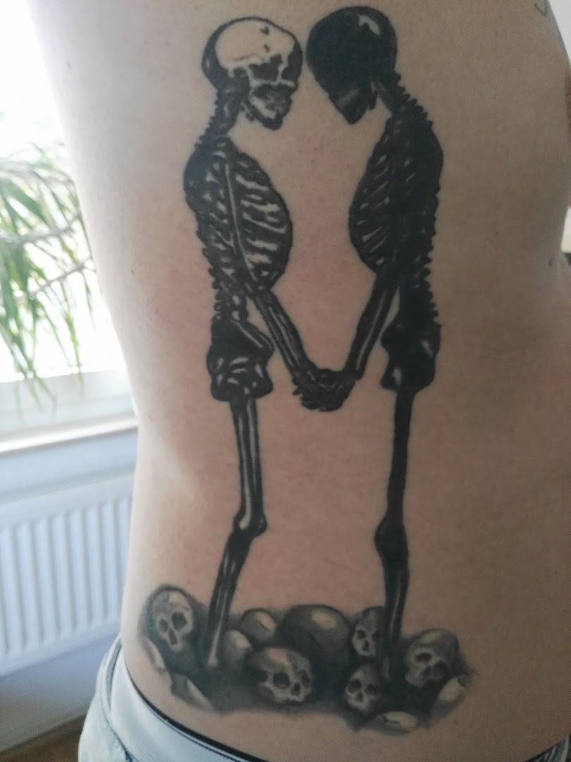 a couple holding hands with a skeleton on their back