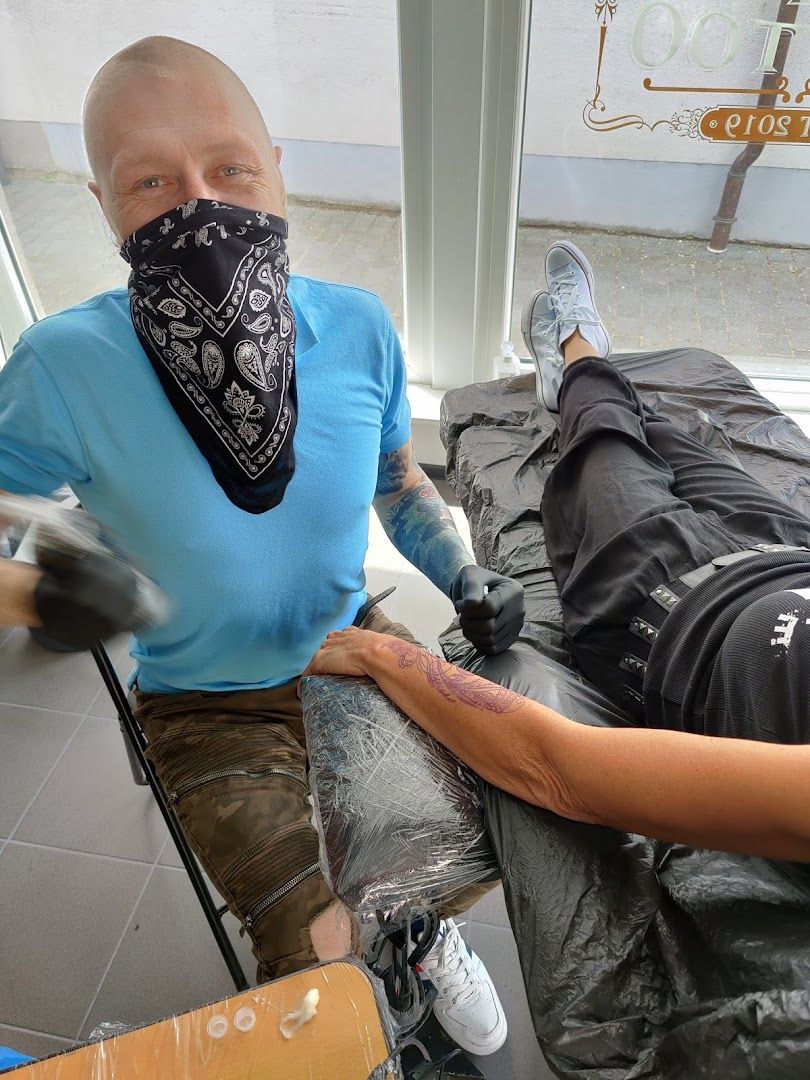 a man in a blue shirt and black mask is getting his narben tattoo done, germersheim, germany