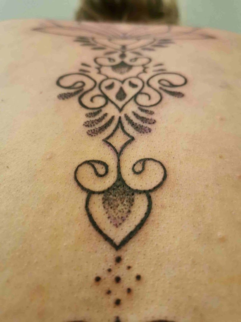 a woman's back with a cover-up tattoo design on it, nordwestmecklenburg, germany