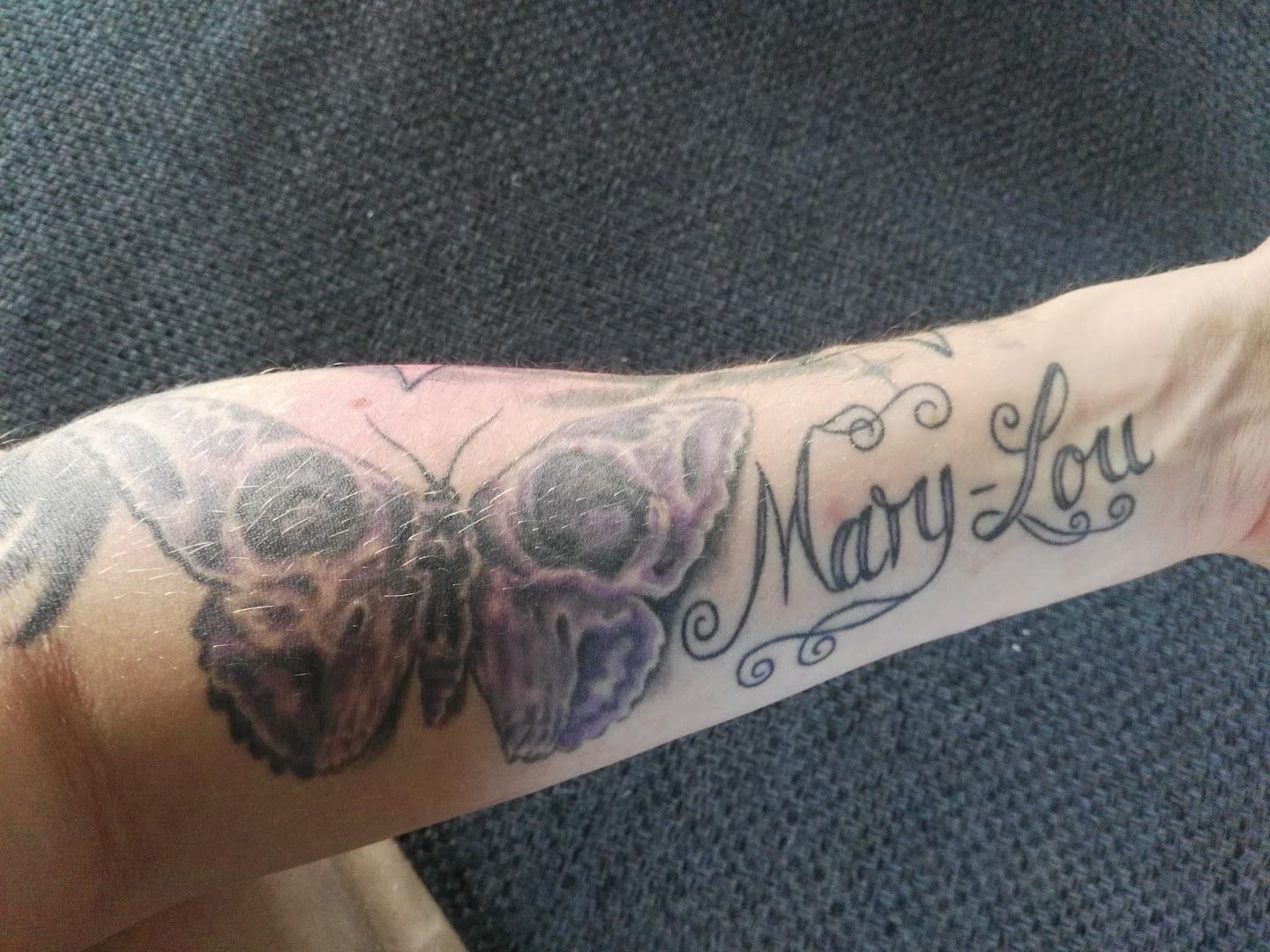 a narben tattoo with a butterfly and the word'may ', bochum, germany