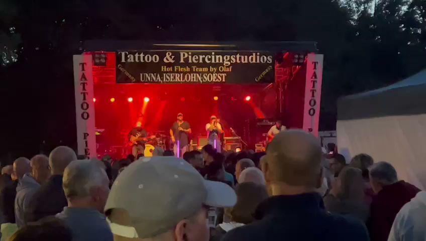 a crowd of people watching a band performing on stage