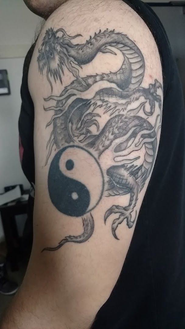 a man with a dragon cover-up tattoo on his arm, ansbach, germany