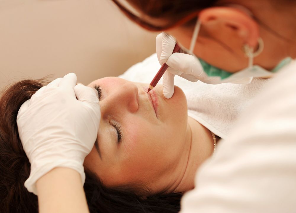 a woman getting her eyebrows done