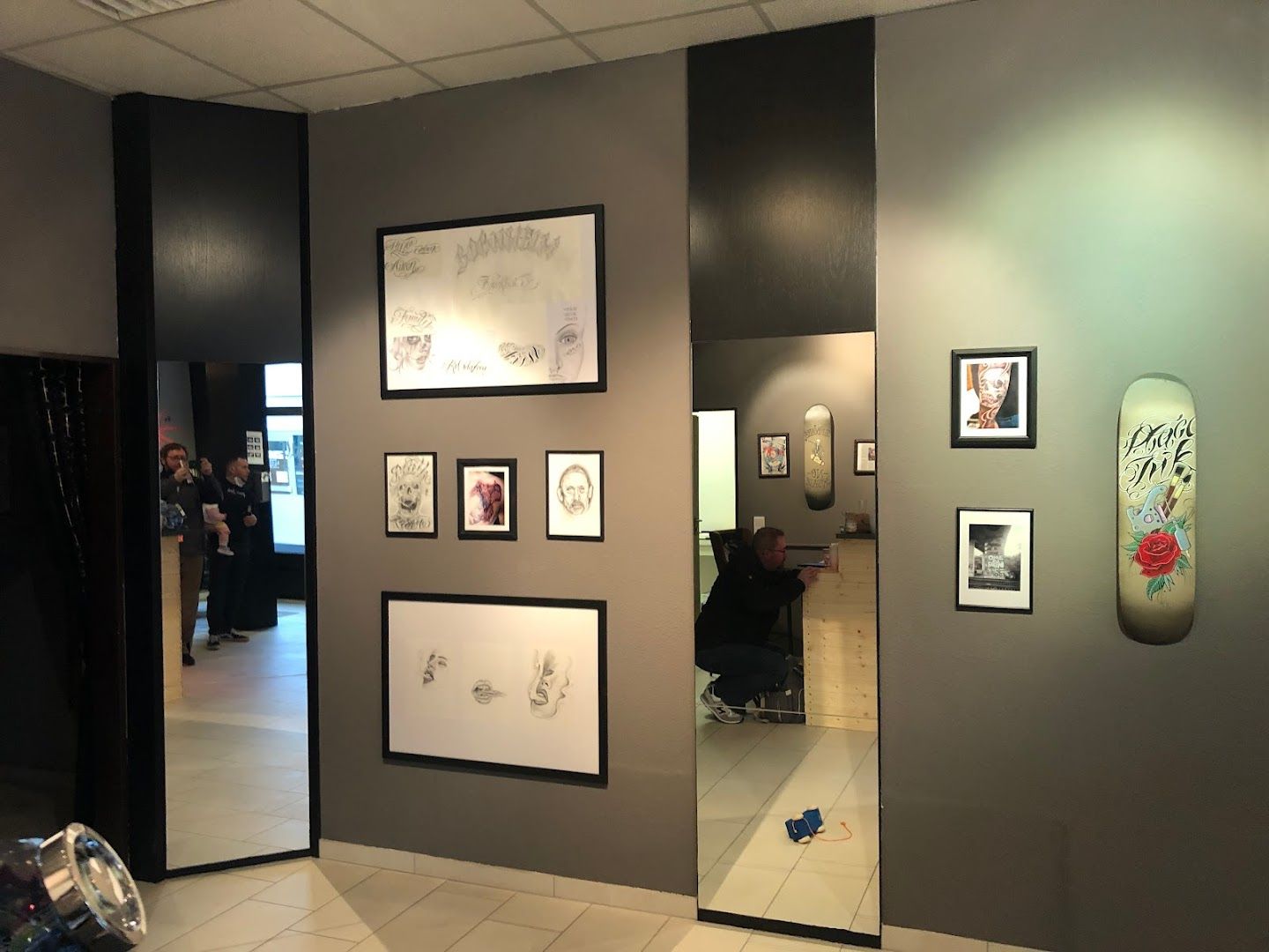 a room with a mirror and pictures on the wall