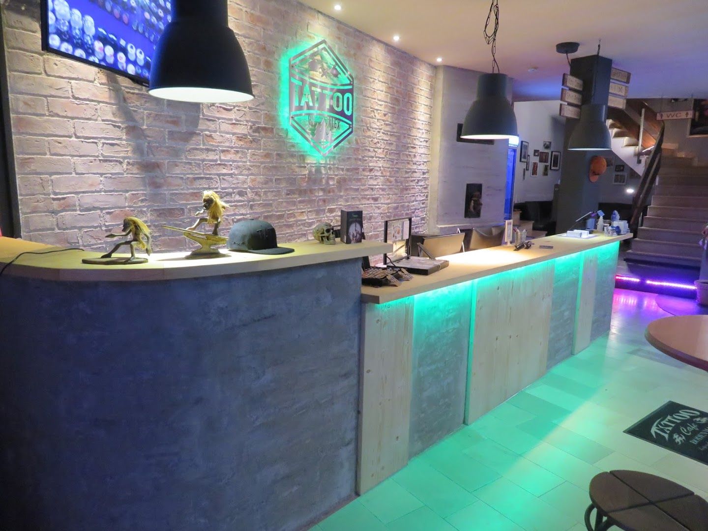 a bar with a stone wall and a neon sign