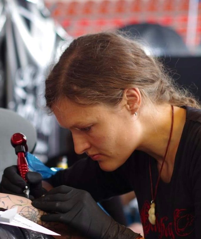a woman is getting her narben tattoo done, ostallgäu, germany