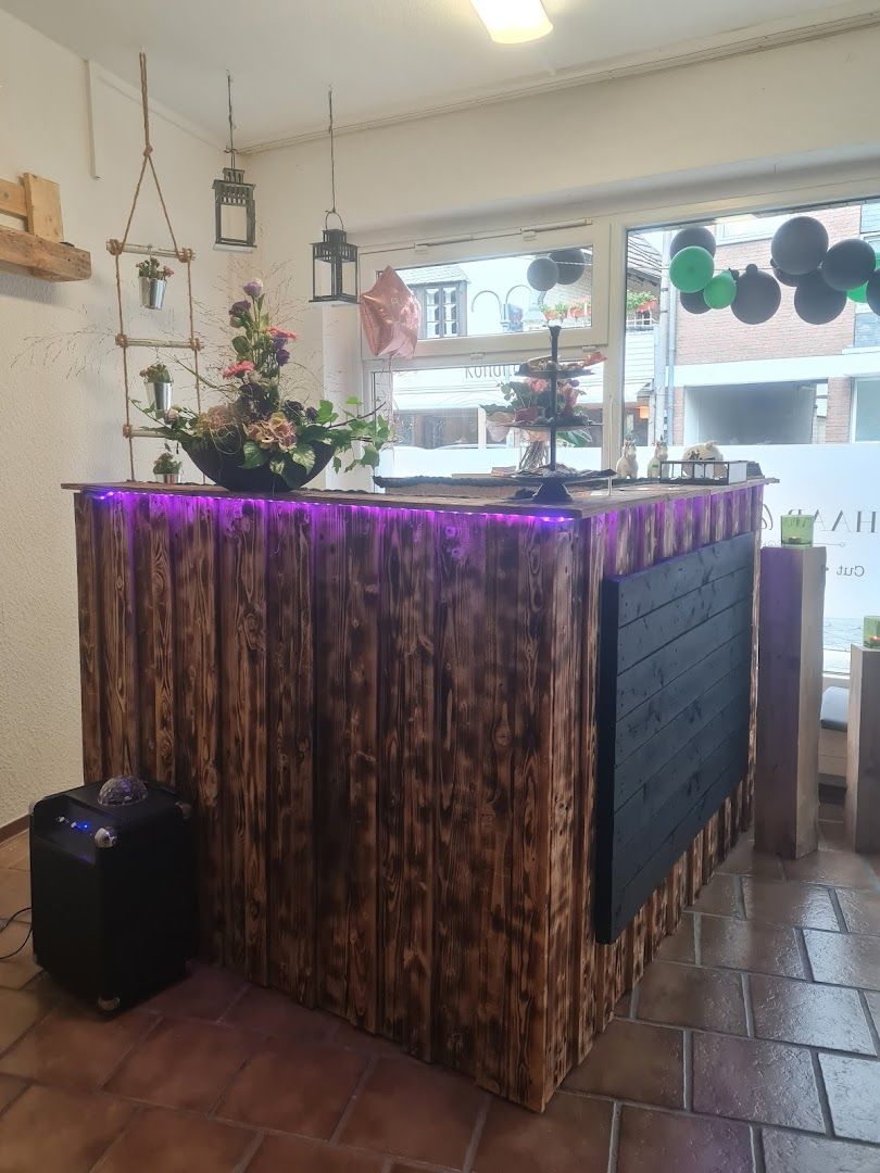 a bar with a wooden counter and purple lights