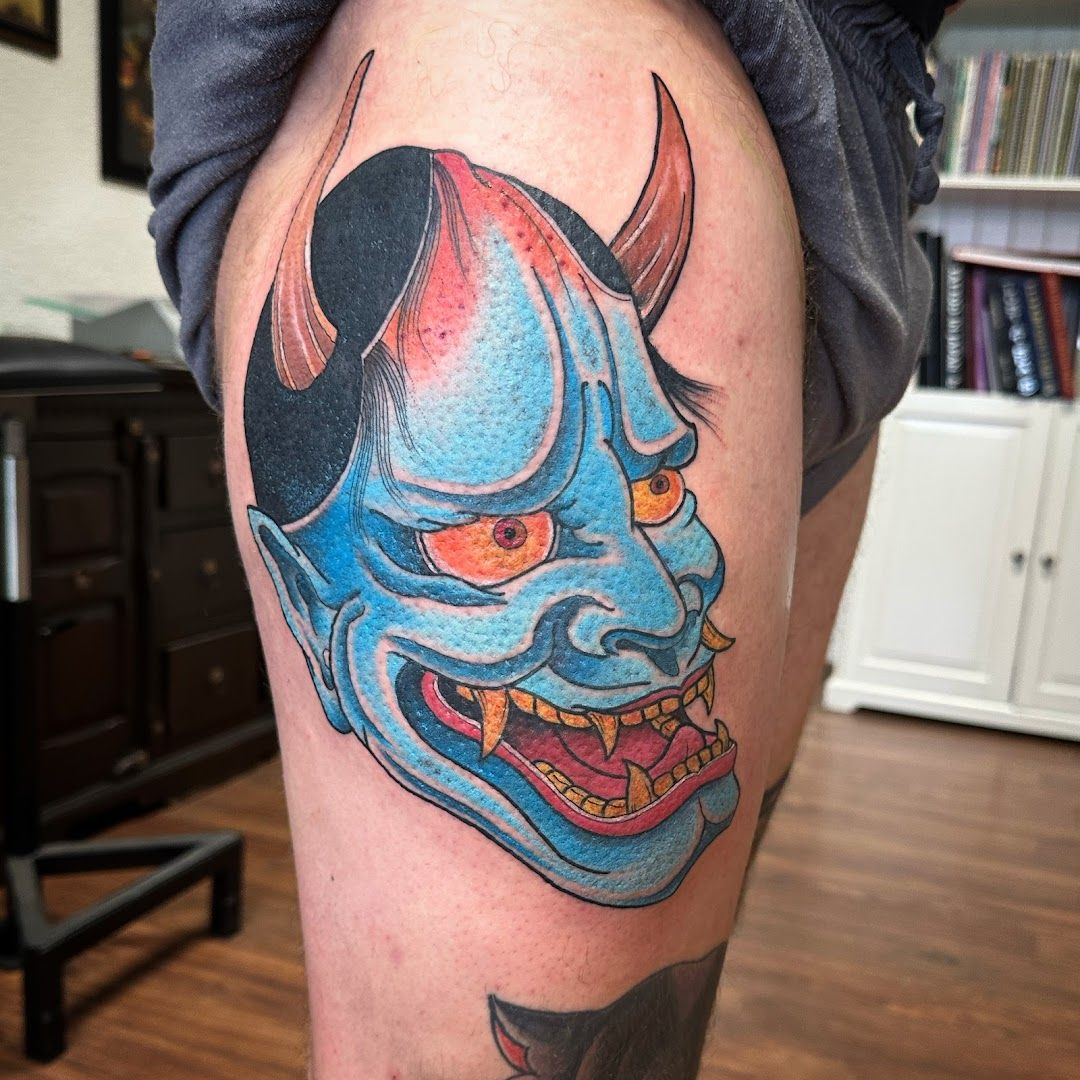 a cover-up tattoo of a demon with a red and blue face, darmstadt-dieburg, germany