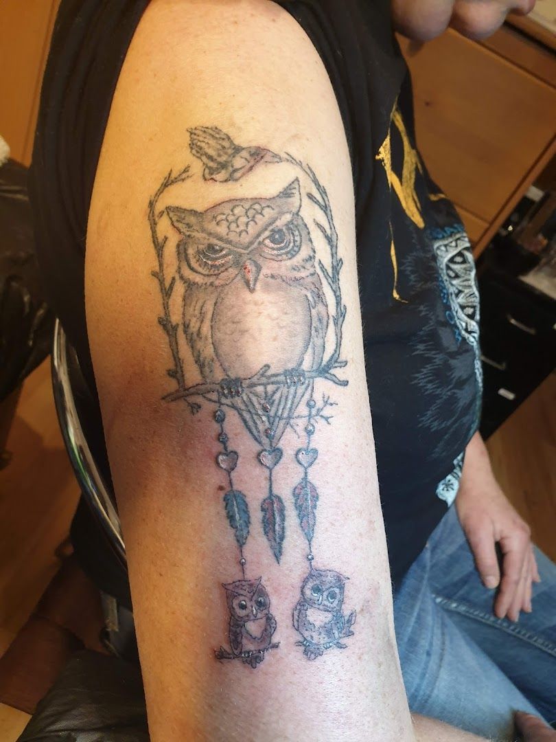 a narben tattoo of an owl and a bird on the arm, ammerland, germany