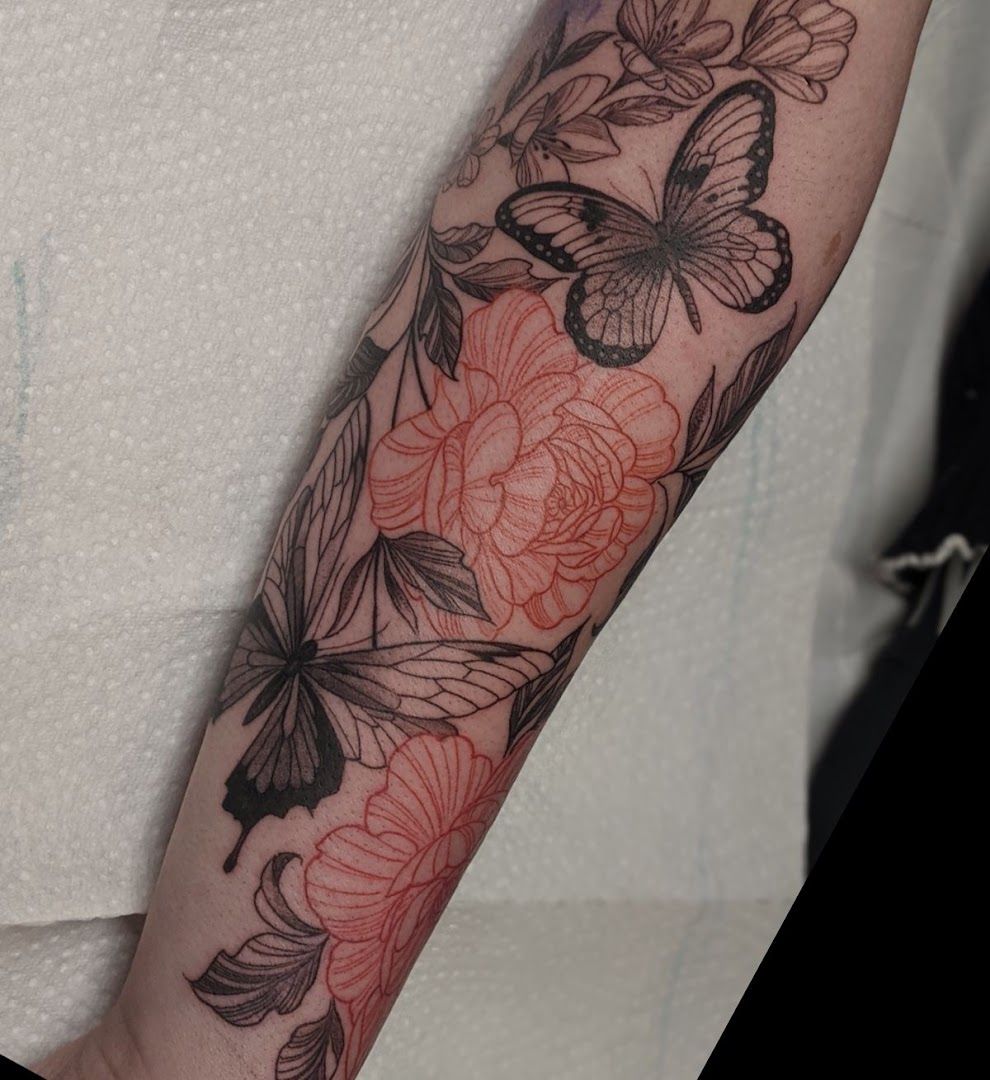 a woman's arm with a cover-up tattoo of flowers and butterflies, bielefeld, germany