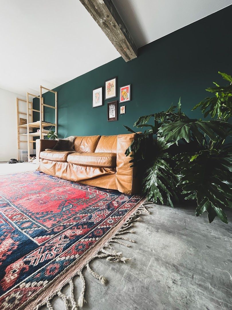 a living room with a large rug and a leather couch