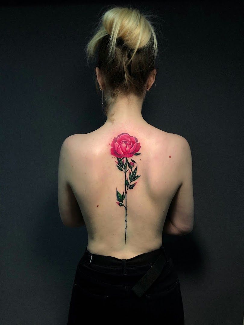 a woman with a rose cover-up tattoo on her back, sonneberg, germany