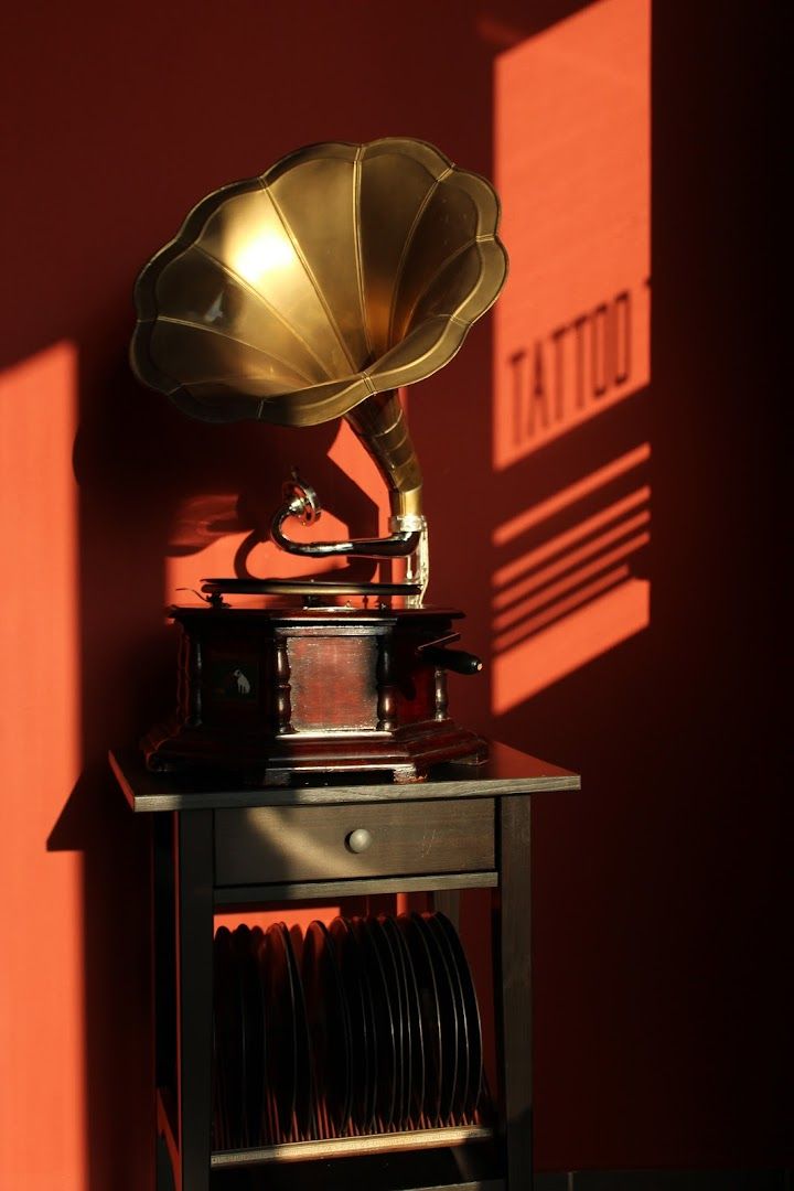 a gramphone on a table in front of a red wall