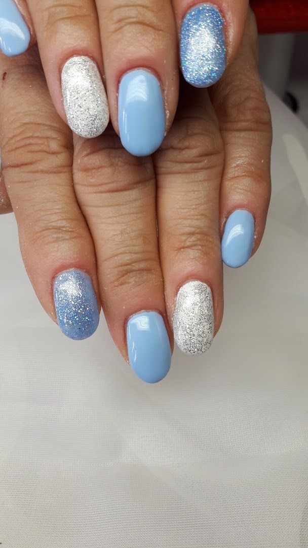 a woman's hand with blue and silver glitter nails