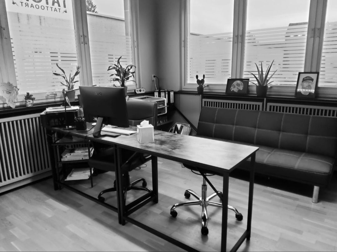 a black and white photo of a desk in an office