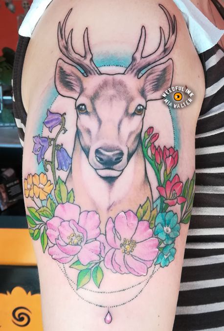 a deer with flowers and leaves on his arm