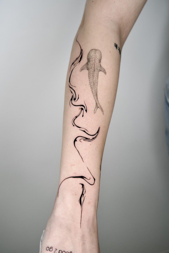 a woman's arm with a narben tattoo of a whale, frankfurt, germany