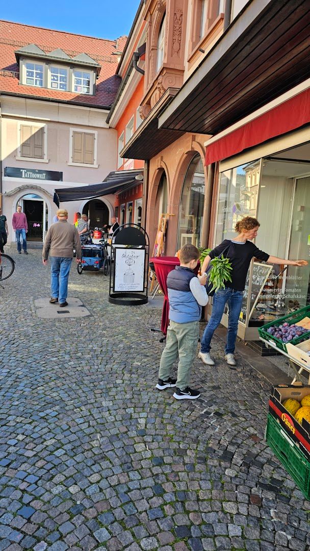 people are shopping in the street outside of a building