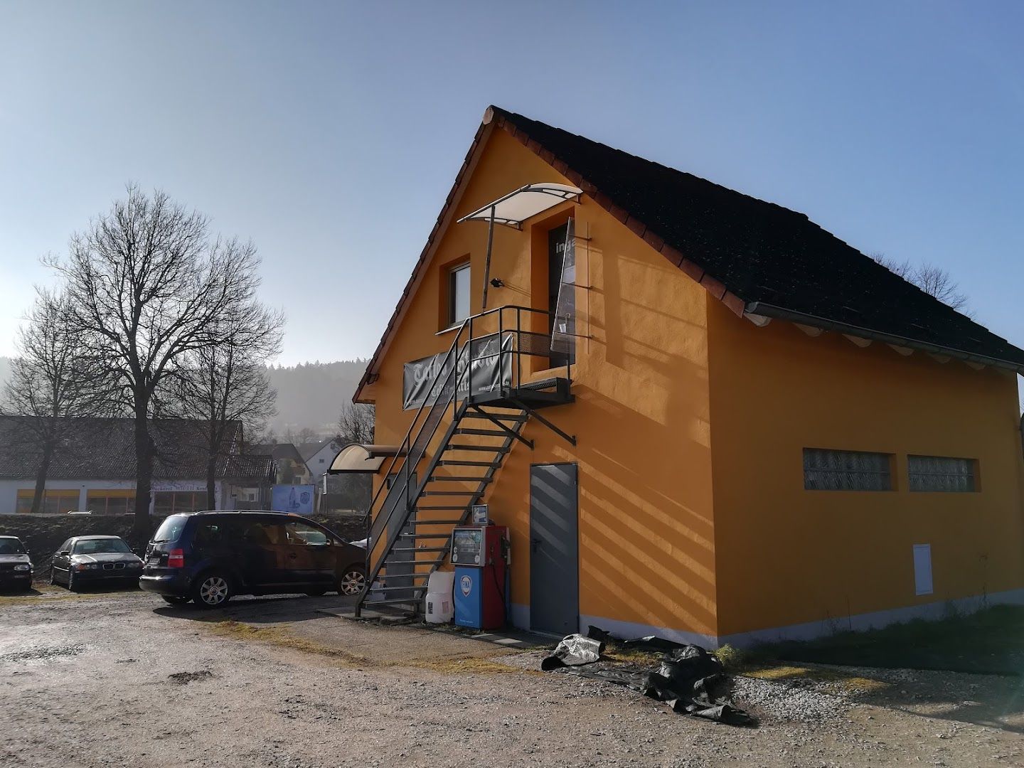 a yellow house with a black roof and a black door