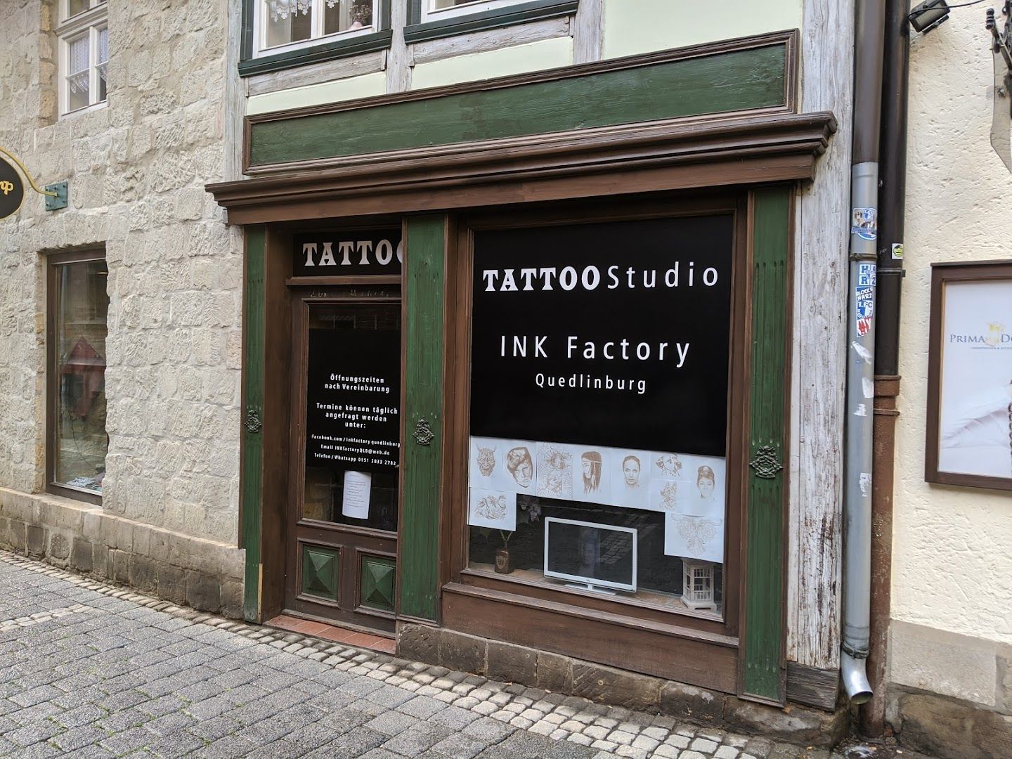 a storefront with a sign that says narben tattoo factory, harz, germany