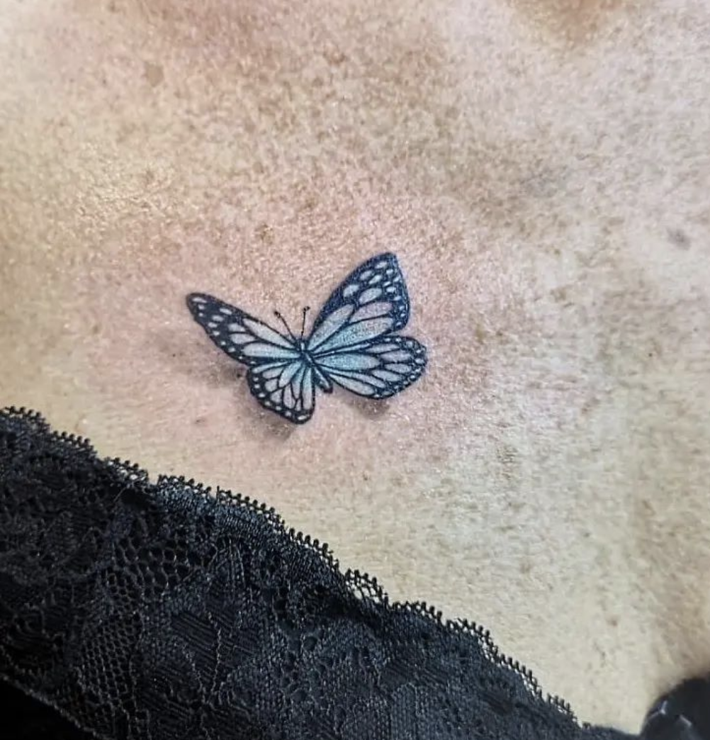 a blue butterfly narben tattoo on the chest, bochum, germany