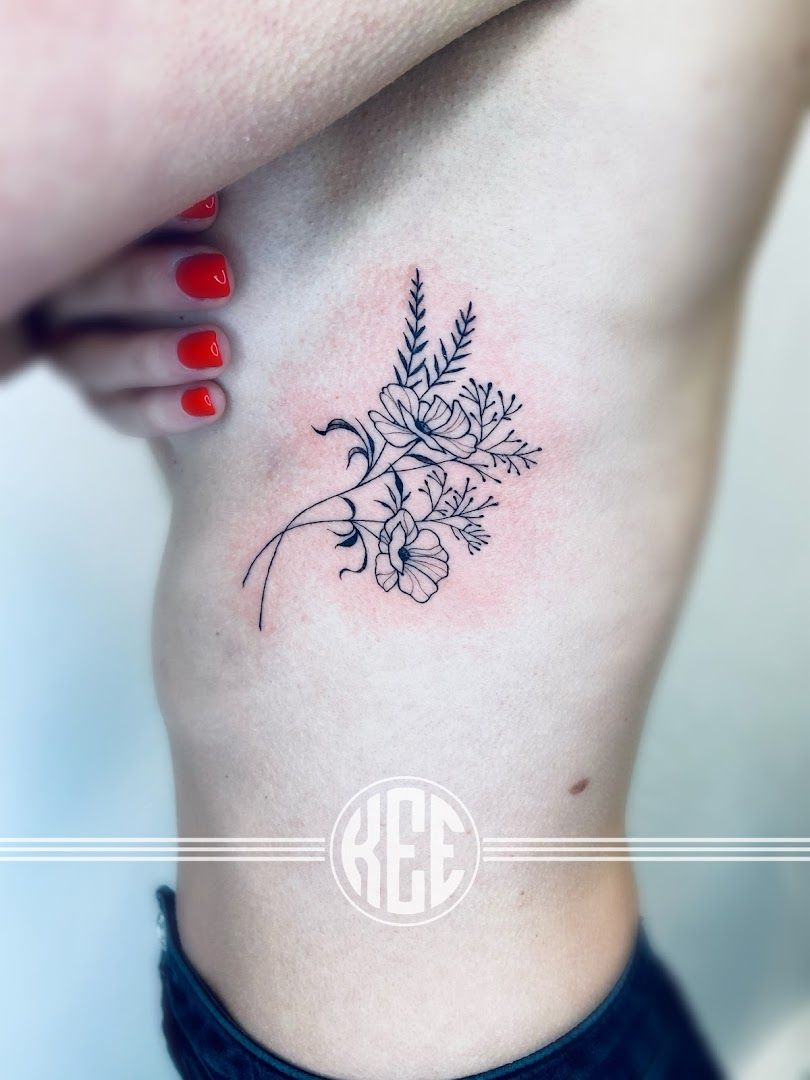 a small narben tattoo of a flower on the side, kleve, germany