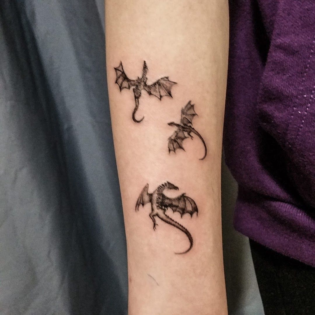 a cover-up tattoo of two dragons on the arm, paderborn, germany