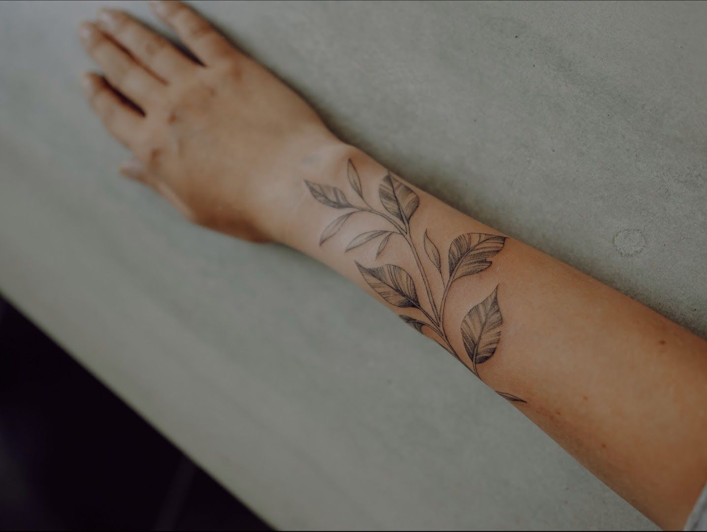 a woman's arm with a narben tattoo of leaves, bayreuth, germany