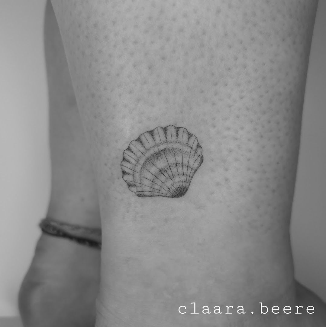 a small black and white narben tattoo of a shell, bremen, germany