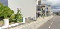a street with a white building and trees