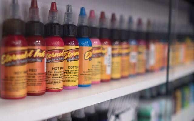 a shelf filled with lots of different colored paints