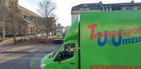 a green truck parked in front of a building