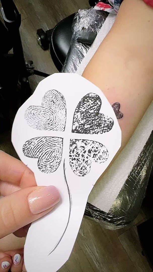 a person holding a white paper heart with four leaves