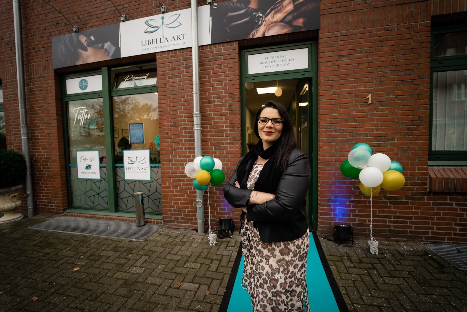 a woman standing outside of a building holding balloons