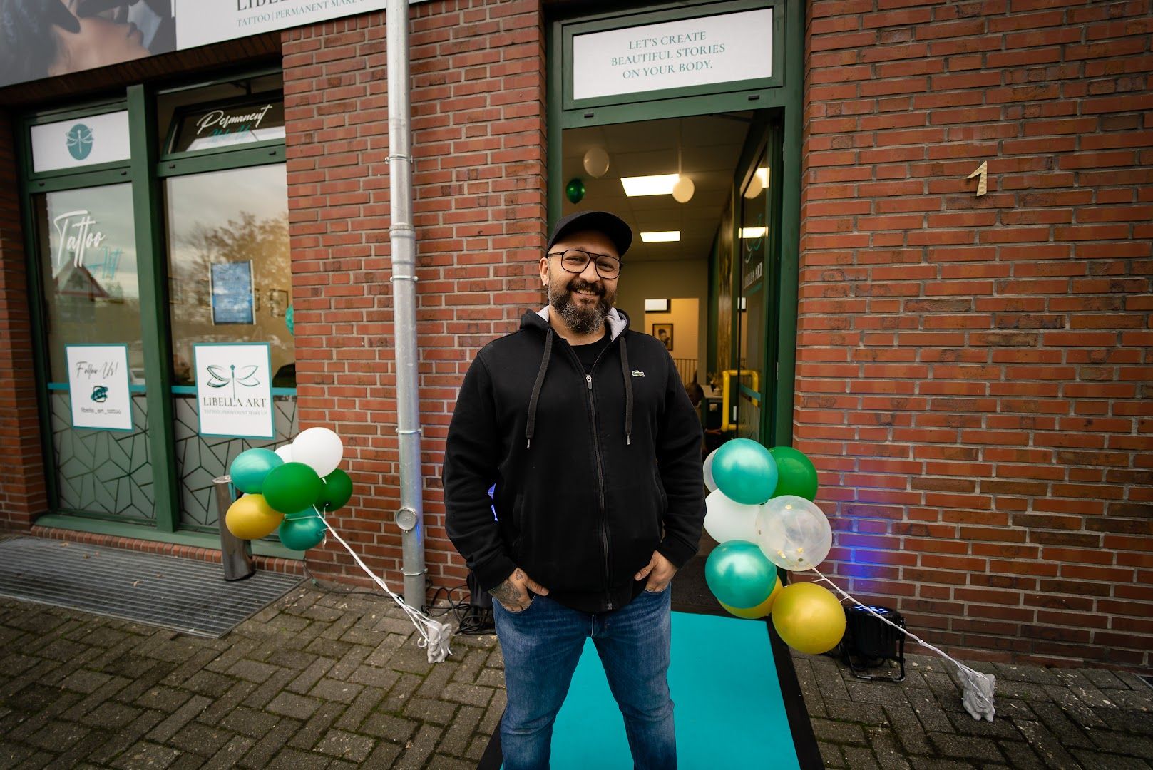 a man standing in front of a building holding balloons