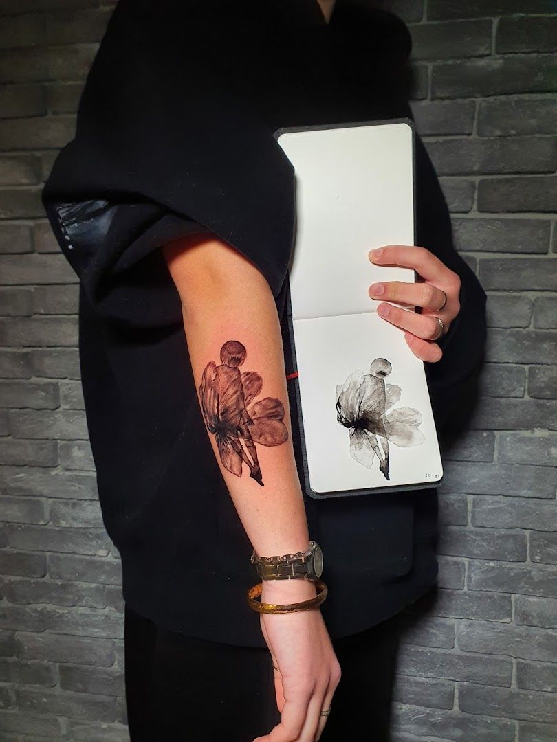 a woman holding a book with a narben tattoo on her arm, göttingen, germany