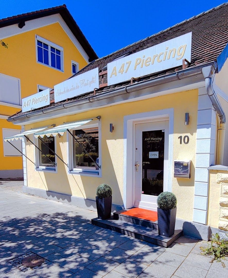 the front of the hotel with a yellow building