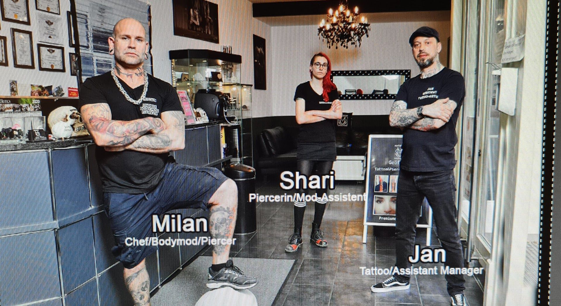 two men sitting in a barber with their arms crossed