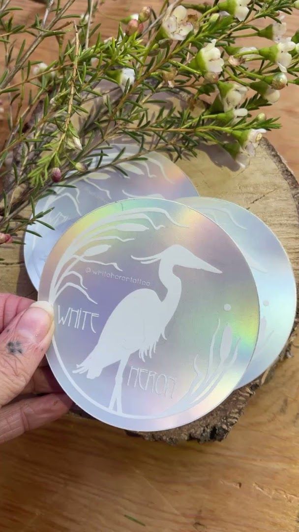 a person holding a glass coaster with a bird on it