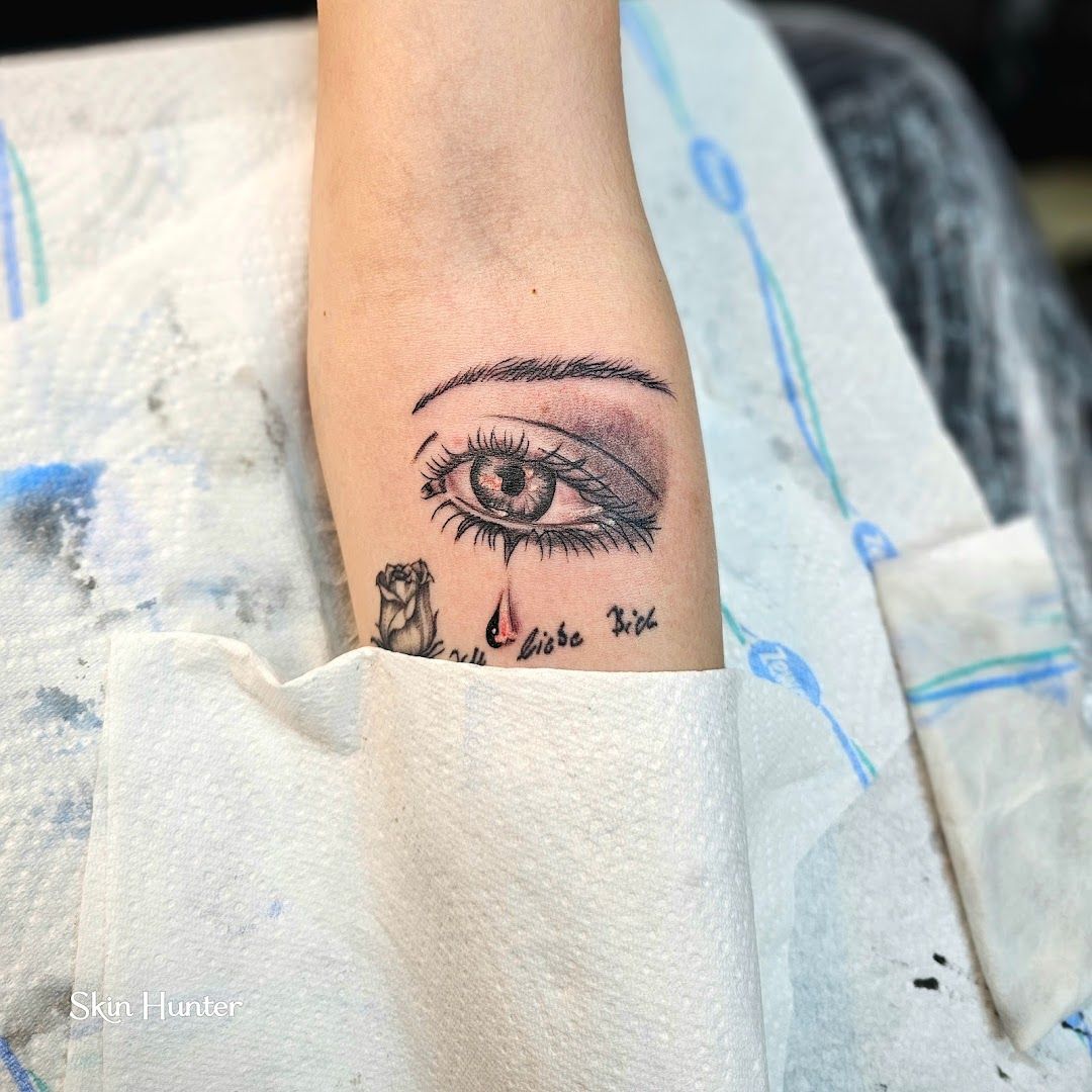 a narben tattoo artist's eye with a flower on the left forearm, paderborn, germany