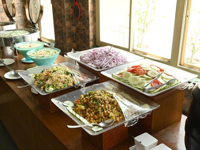 Salad counter with sliced onions, cucumber, tomato and chickpea salad on the buffet at Rangmanch Farms, an event and corporate outing venue in Gurugram near Delhi